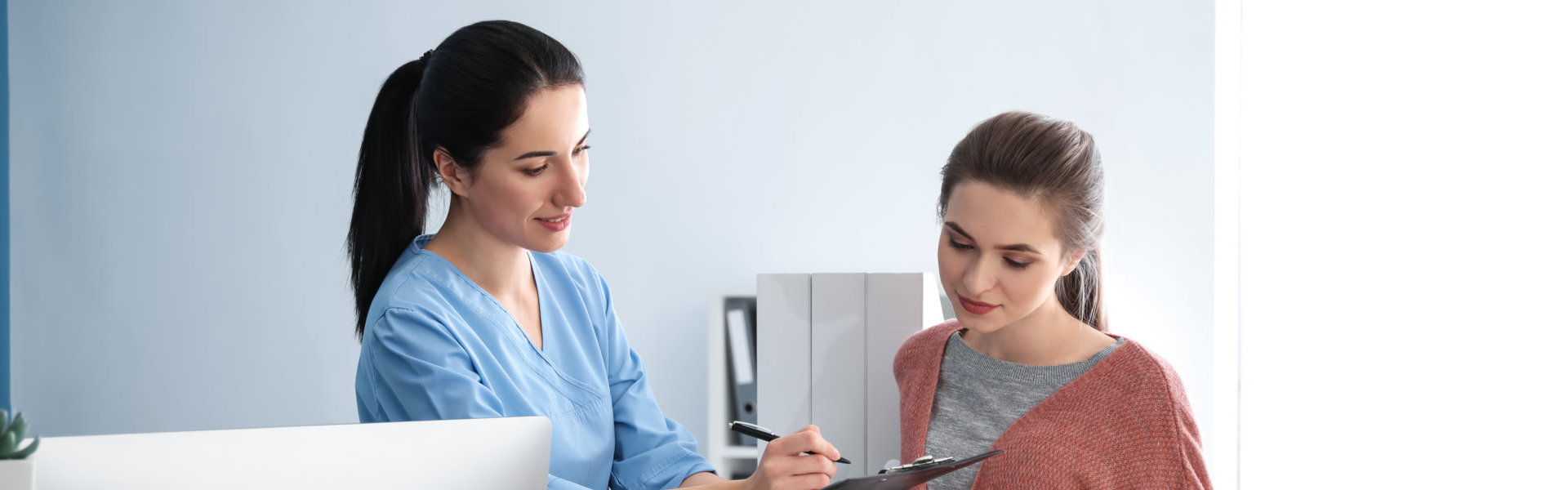 Young woman near reception desk in clinic