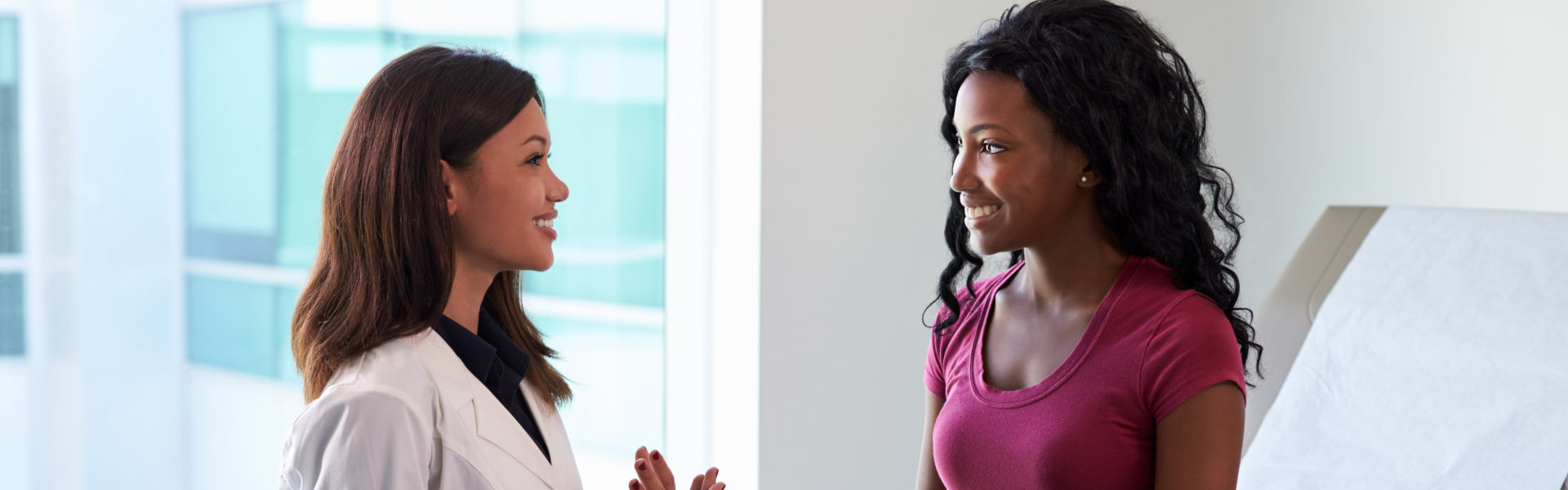 Female Doctor Meeting With Patient In Exam Room